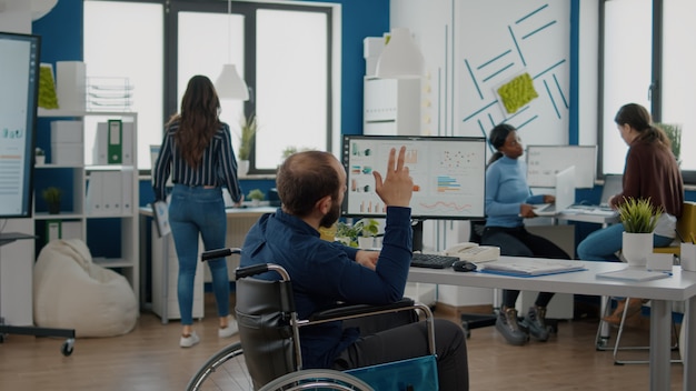 Foto empresario y empleado no válidos que trabajan juntos en un proyecto financiero para la puesta en marcha de una empresa, comparando estadísticas que miran la pc y la computadora portátil para discutir la búsqueda de una solución para la evolución del negocio