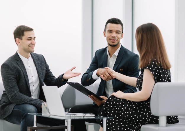 Empresario y empresaria dándose la mano después de discutir el contrato