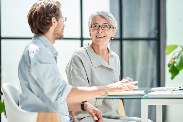 Empresario y empresaria discutiendo temas de trabajo juntos