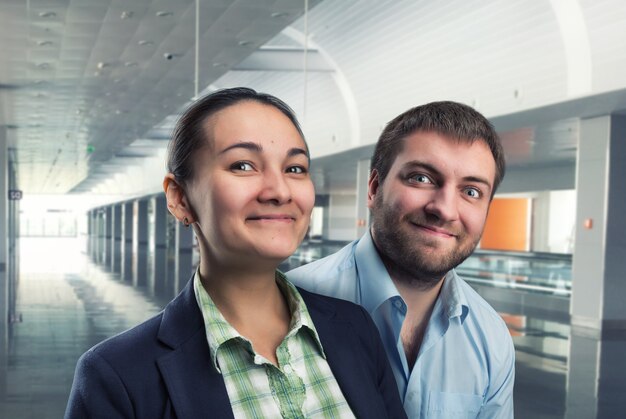 El empresario y la empresaria están sonriendo en la oficina.