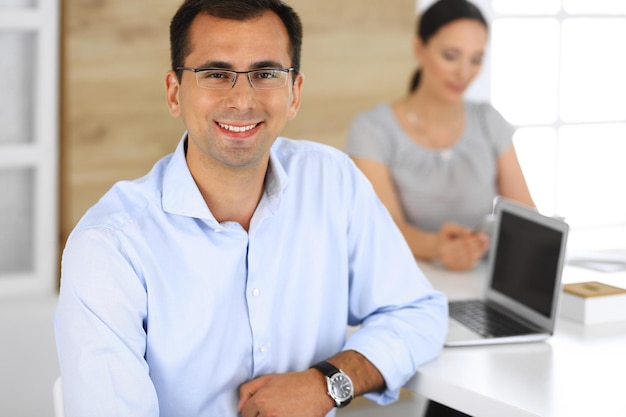 Foto empresario y empresaria hispana usando tableta en la oficina moderna captura de cabeza del empresario en la reunión grupo de personas diversas asociación de trabajo en equipo y concepto de negocio