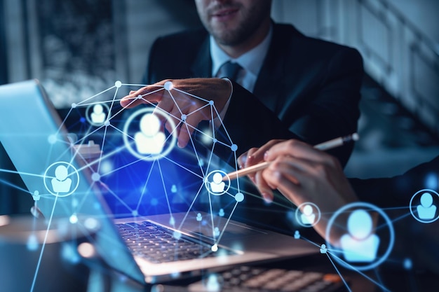 Empresario y empresaria con ropa formal trabajando juntos en busca de nuevos empleados para contratar para consultoría de negocios internacionales Iconos de medios sociales de recursos humanos sobre el fondo panorámico moderno de la oficina