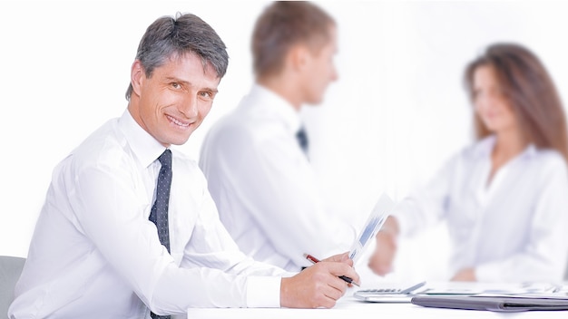 Empresario y empresaria sonriente un apretón de manos sobre la mesa de conferencias