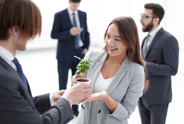 Empresario y empresaria sosteniendo una olla con brotes el concepto de ecobusiness