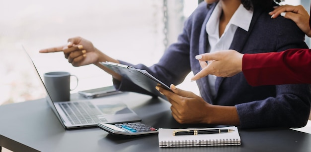 Empresario Empresario asiático y mujer de negocios discutiendo un nuevo proyecto de negocio en una tableta en la reunión moderna En la oficina moderna concepto casual de negocios asiático