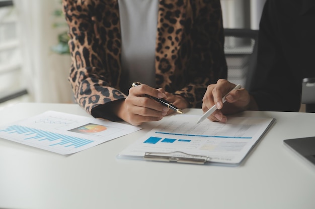 Empresario Empresario asiático y mujer de negocios discutiendo un nuevo proyecto de negocio en una tableta en la reunión moderna En la oficina moderna concepto casual de negocios asiático