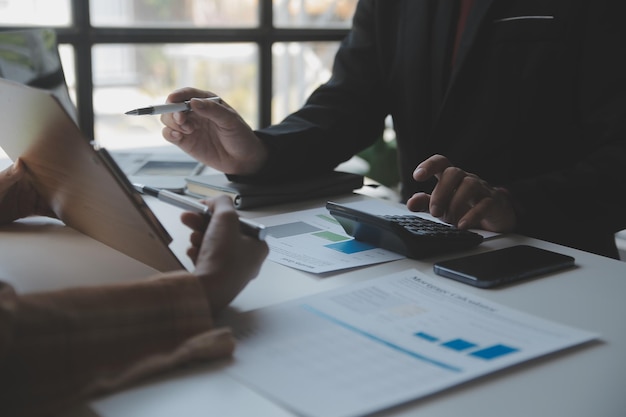 Empresario Empresario asiático y mujer de negocios discutiendo un nuevo proyecto de negocio en una tableta en la reunión moderna En la oficina moderna concepto casual de negocios asiático