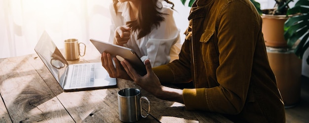 Empresario Empresario asiático y mujer de negocios discutiendo un nuevo proyecto de negocio en una tableta en la reunión moderna En la oficina moderna concepto casual de negocios asiático