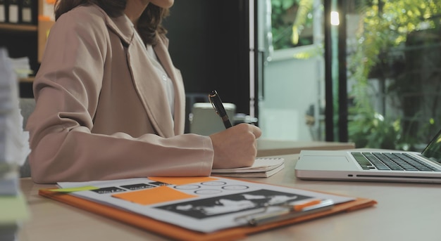 Empresario empresario y empresaria asiáticos discutiendo un nuevo proyecto empresarial en una tableta en una reunión moderna en una oficina moderna Concepto informal de negocios asiático