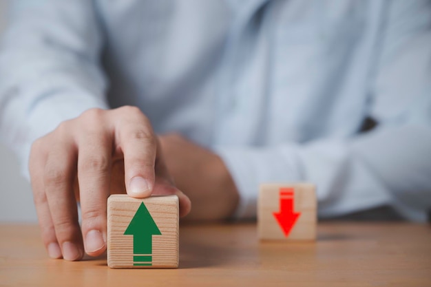 Foto empresario empujando la flecha verde hacia arriba que imprime la pantalla en un bloque de cubo de madera para la planificación financiera del precio de clasificación de la hipoteca de la tasa de interés y el concepto de crecimiento de la inflación