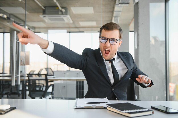 Foto empresario enojado sentado en la mesa y gritando