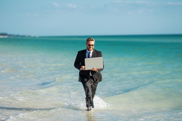 Foto empresário entusiasmado em fato de mergulho corre no mar empresário engraçado conceito de negócio cômico louco trabalho remoto on-line negócio de verão louco estilo de vida de negócios engraçado empresário freelancer engraçado