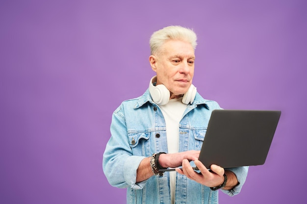 Empresário envelhecido com cabelos grisalhos digitando no teclado do laptop