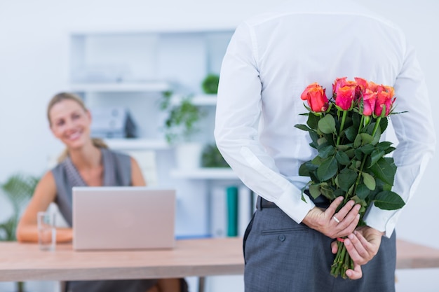 Empresario escondiendo flores detrás para colega