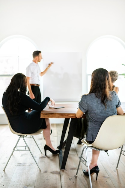 Empresário escrevendo em um quadro na sala de reuniões