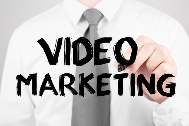 Empresário escrevendo palavra video marketing com marcador, conceito de negócio