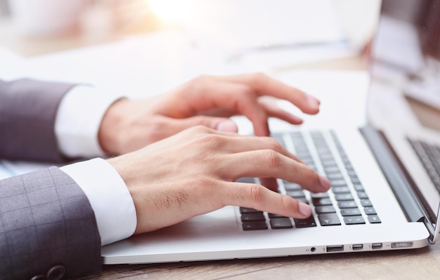 Empresario escribiendo a mano en el teclado de una computadora portátil en la oficina Concepto de negocios y finanzas