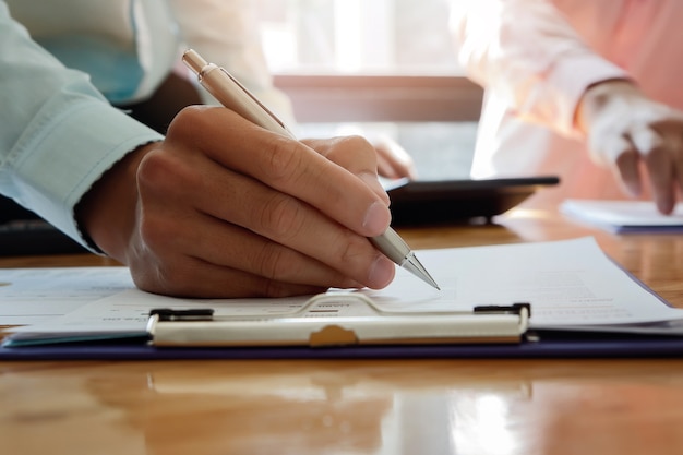 Empresario escribiendo o señalando en el informe de papel. Concepto de estrategia empresarial.