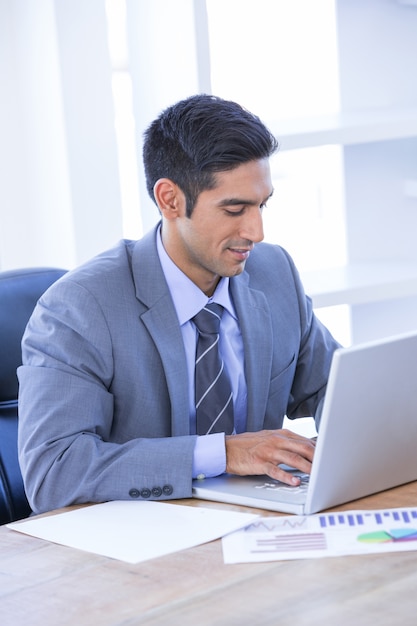 Empresario escribiendo en su computadora portátil