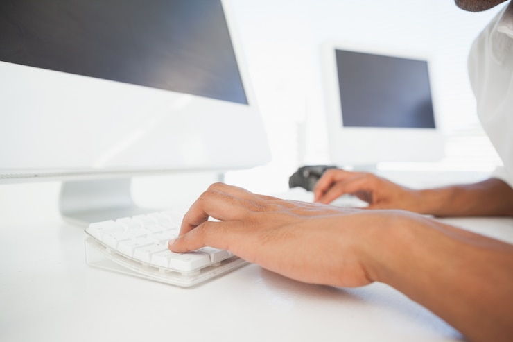 Foto empresario escribiendo en el teclado en el escritorio