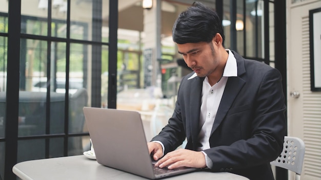 Empresário está digitando no teclado do laptop para trabalhar