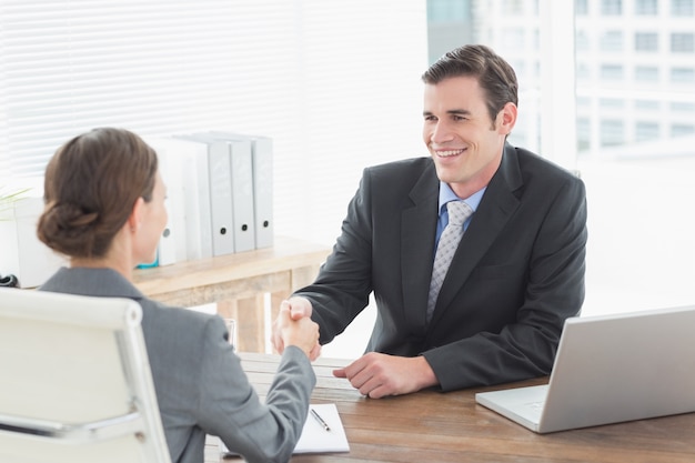 Empresario estrecharme la mano con una empresaria