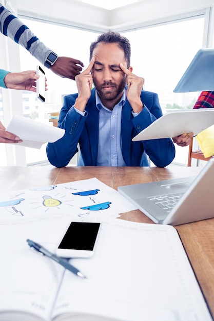 Foto empresário estressante sentado com a cabeça nas mãos no escritório criativo