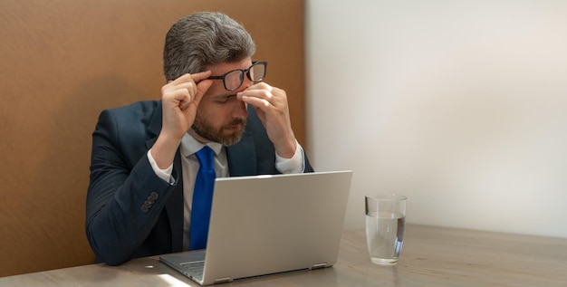 empresario con exceso de trabajo tiene dolor de cabeza mientras trabaja en el espacio de copia empresario con exceso de trabajo tiene dolor de cabeza foto de hombre de negocios con exceso de trabajo tiene dolor de cabeza hombre de negocios con exceso de trabajo tiene dolor de cabeza en la oficina