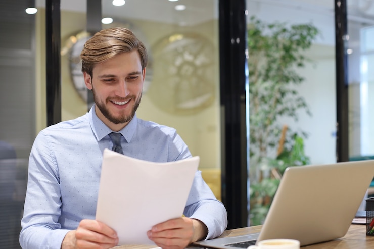 Foto el empresario exitoso está estudiando documentos con mirada atenta y concentrada.