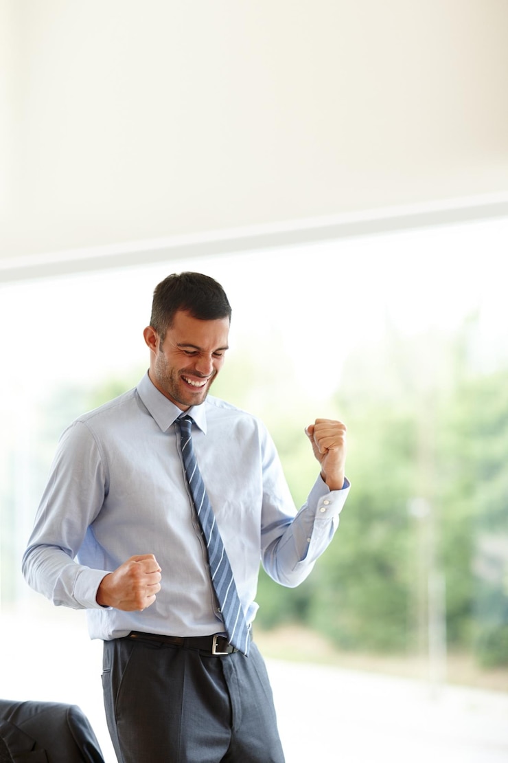 Foto empresario exitoso y feliz en el lugar de trabajo con logros para el fin de semana y descanso en la agencia contador celebrar y el puño bomba para ganar promoción de trabajo y bonificación o oportunidad para el mercado de valores