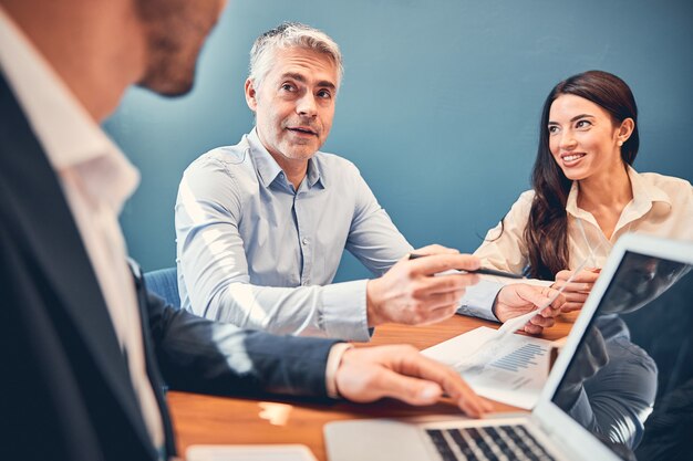 Empresário explicando ao colega um novo projeto no escritório moderno