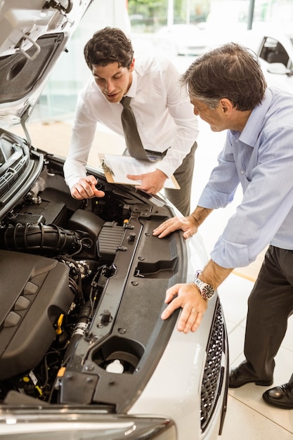 Foto empresario explicando los detalles del coche