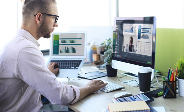 Empresário fala conversa em videochamada com colegas em instruções on-line durante o auto-isolamento e a quarentena. conferência em grupo de webcam com colegas de trabalho no laptop no escritório. epidemia de gripe e covid-19.