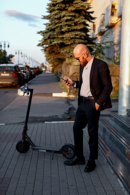 Foto empresário falando ao telefone ao lado da scooter elétrica