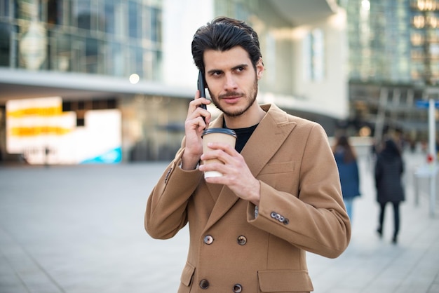 Empresário falando ao telefone e tomando café