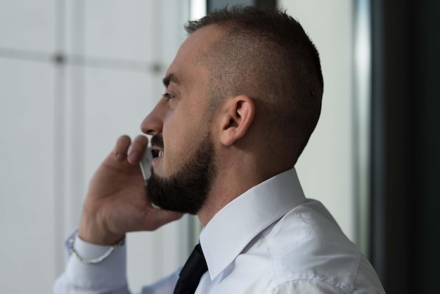 Empresário falando ao telefone no escritório