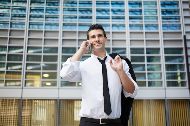 Empresário falando com celular em ambiente urbano