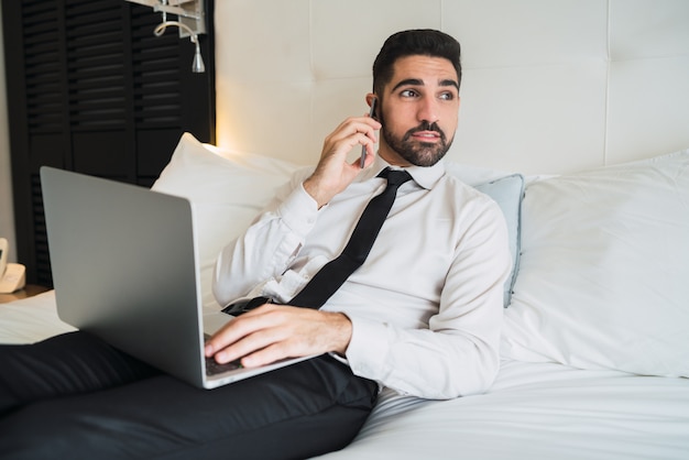 Empresário falando no telefone no quarto de hotel