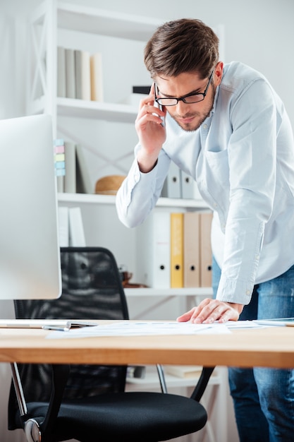 Empresário fechando contrato assinando documentos na mesa do escritório vestindo camisa branca