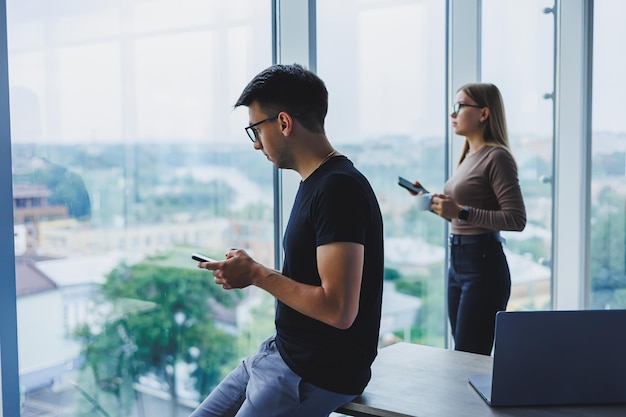 Empresário feliz relaxado com um telefone nas mãos um estudante em sua mesa uma mesa em um café uma pessoa calma positiva relaxamento uma pausa um sonho um descanso do computador não sente estresse