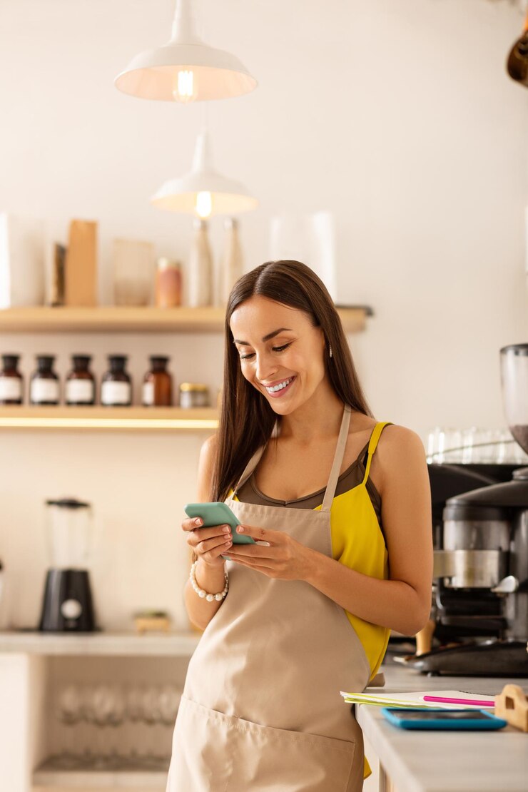 Empresário feminino dono de café lendo mensagem no telefone