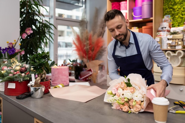 Empresário florista prepara um buquê para venda no dia dos namorados