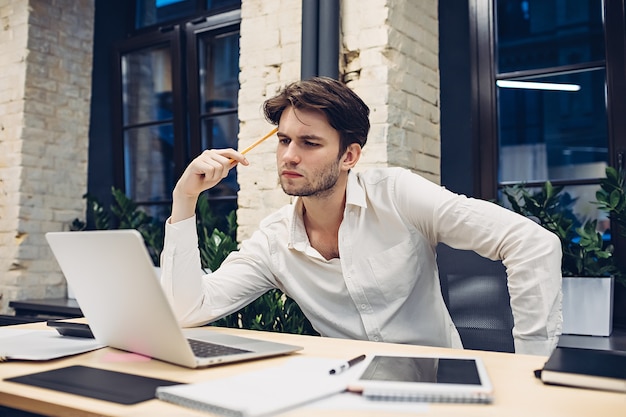 Empresário focado trabalhando em um laptop na mesa do escritório