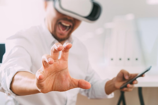 Foto empresario con gafas de realidad virtual en la oficina moderna con teléfono móvil con auriculares vr