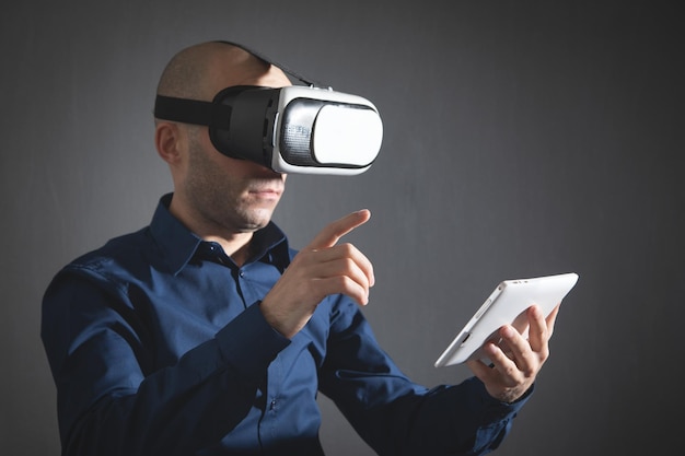 Empresario con gafas de realidad virtual con tableta digital