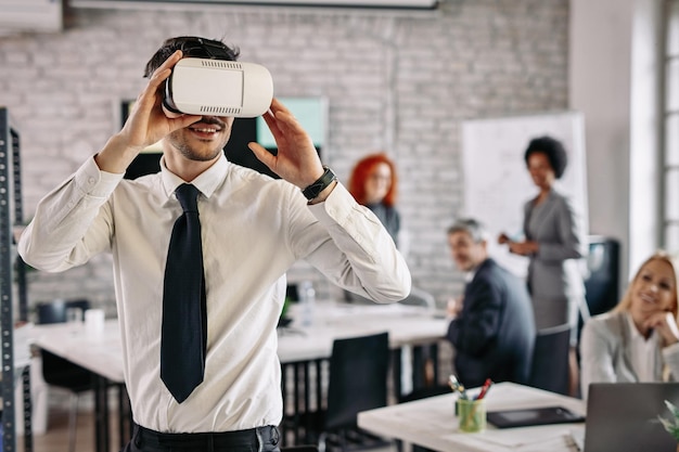 Empresario con gafas VR y divirtiéndose en el trabajo Hay gente en el fondo