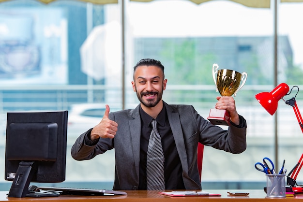 Foto empresário ganhando troféu da copa no escritório