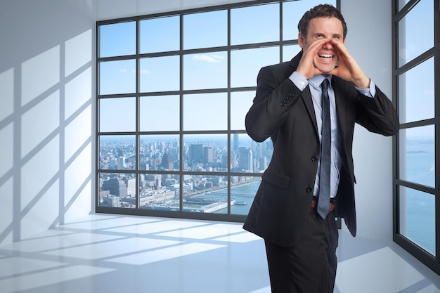 Empresario gritando contra la habitación con una gran ventana que muestra la ciudad