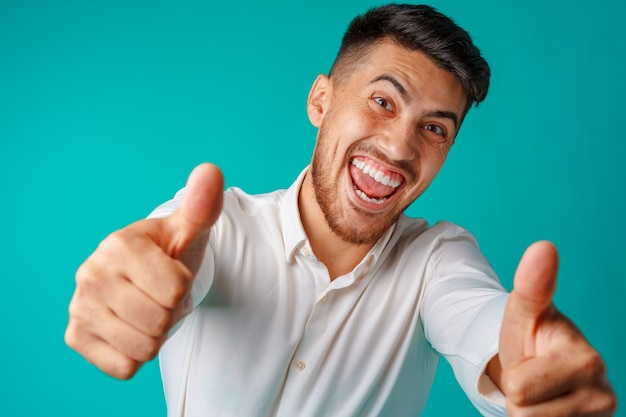 Empresario guapo positivo mostrando el pulgar hacia arriba gesto