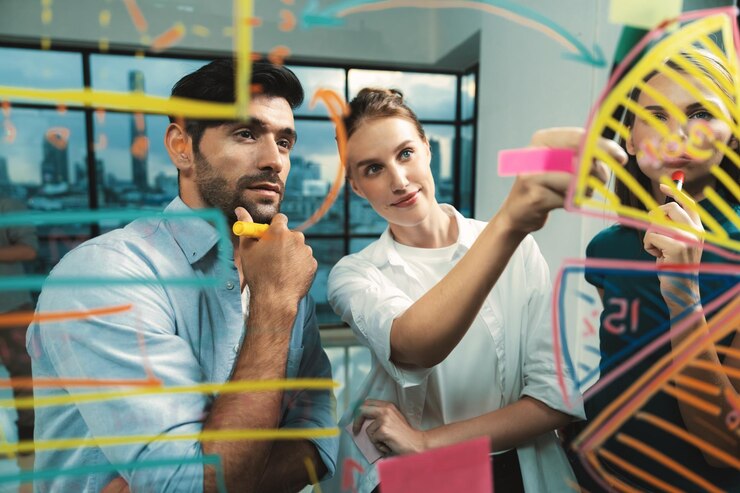 Foto un empresario hábil sonriente escribiendo un gráfico en una pared de vidrio para su compañero de trabajo tracery